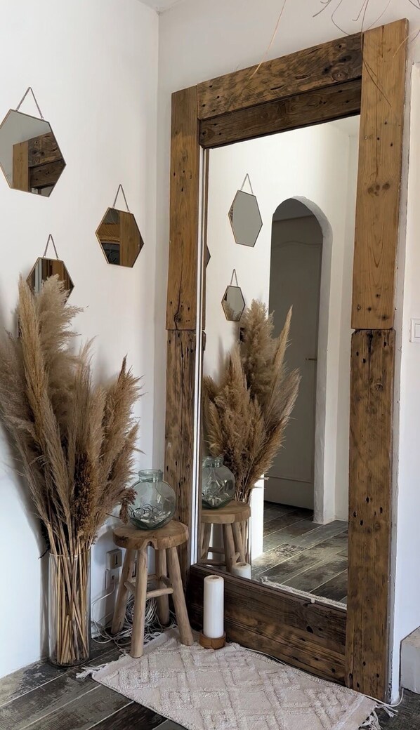 A room with a large mirror, hexagonal mirrors, and tall pampas grass in vases. - Villa finca Ibiza (Brignoles)