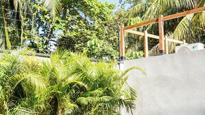 Une piscine entourée d’une végétation luxuriante et agrémentée d’une pergola en bois.