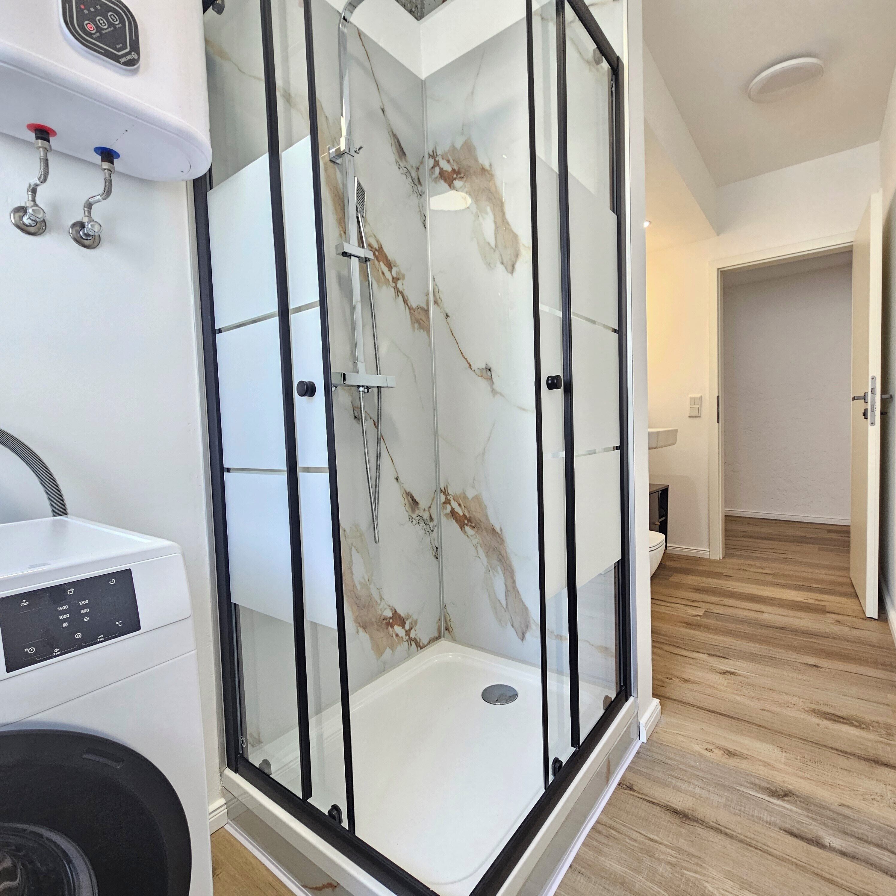 Comfort appartement | Badkamer | Een douche, een regendouche, een haardroger, handdoeken