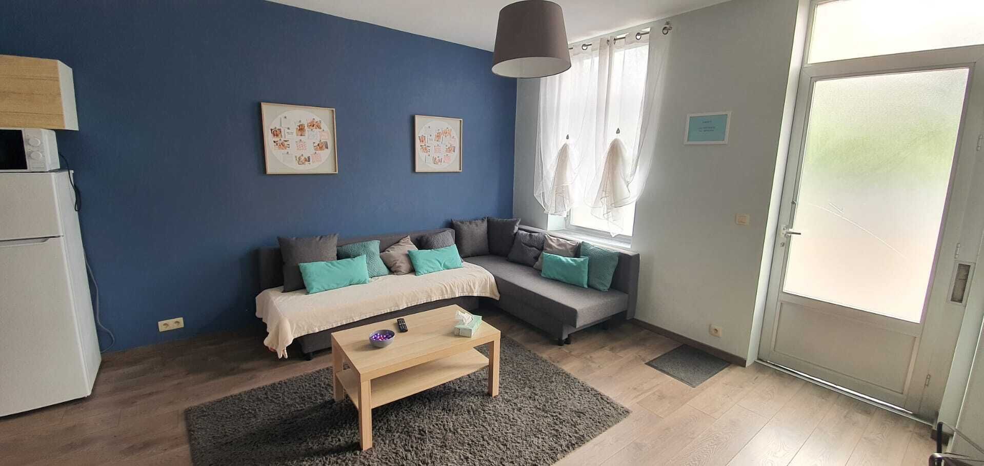 A modern living room with a sofa set, a coffee table, and artwork on the walls.