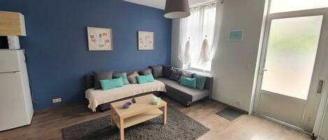 A modern living room with a sofa set, a coffee table, and artwork on the walls.