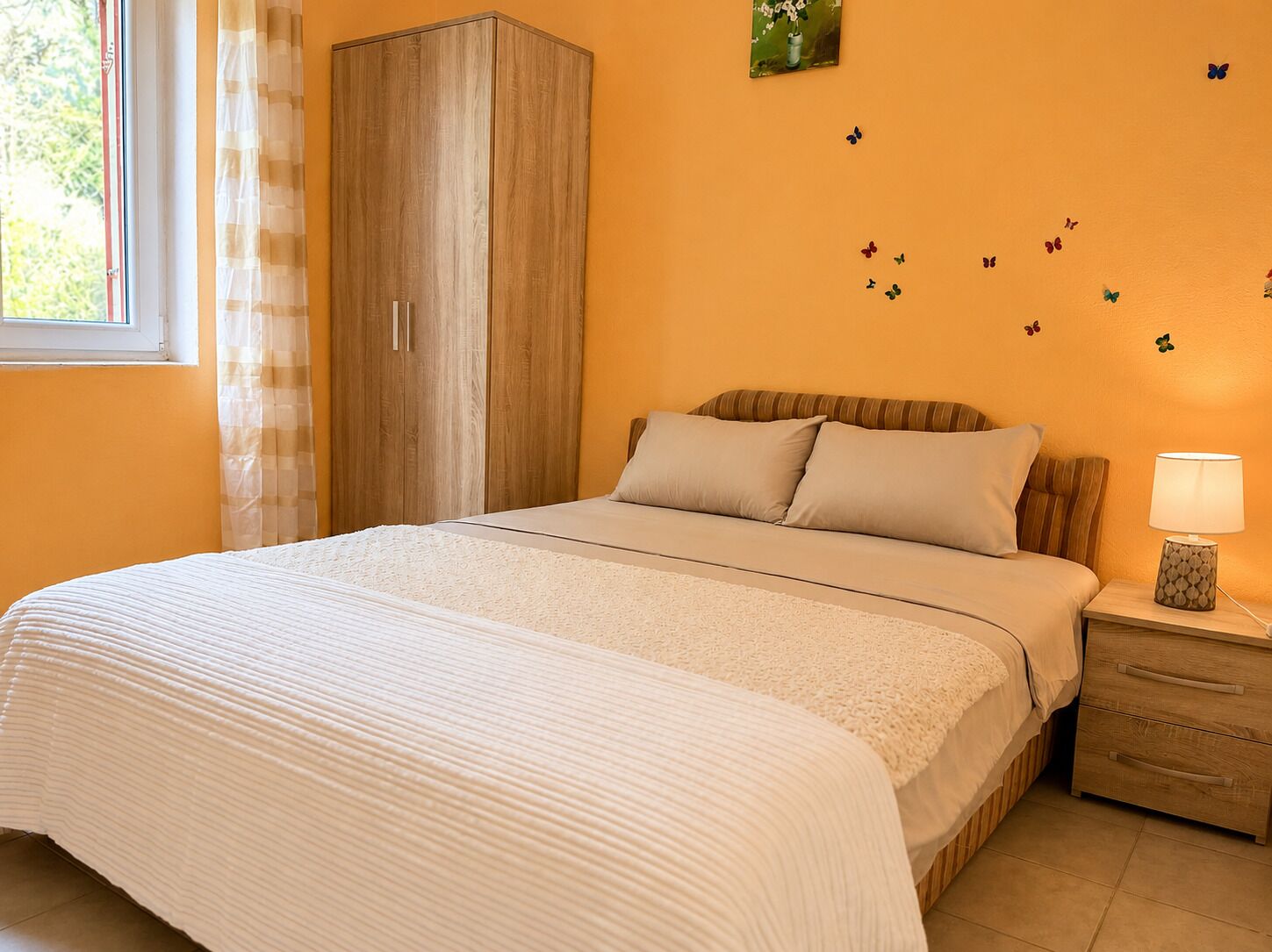 A bedroom with a bed, nightstand, and wardrobe.