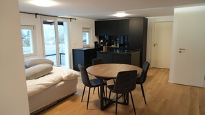 Un espace de vie compact comprenant un coin repas, une kitchenette et un canapé.