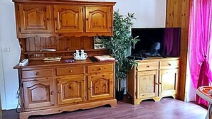 A living room with wooden furniture, a television, and a potted plant. - Casa del sole Oulx vicino alle piste da sci (Oulx)