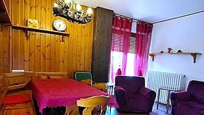A wooden interior with a bed, a chair, a table, and a sofa. - Casa del sole Oulx vicino alle piste da sci (Oulx)