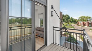 A balcony with a view of a parking lot and a building. - New Luxury Condo in The Heart of Nolensville (Nolensville)
