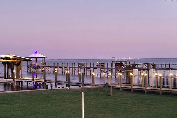 A waterfront pier with wooden structures and seating areas, connected by walkways. - Launch & Lounge: Rocket views, pool and dock (Titusville)