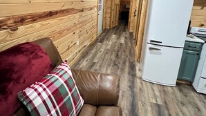 Un interior de madera con un sofá de cuero, un refrigerador y un equipo de aire acondicionado.