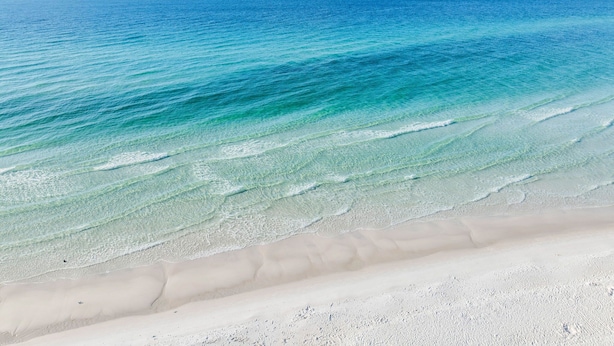 Una playa con agua turquesa cristalina y una orilla arenosa.