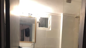 Un baño pequeño con lavabo, espejo y ventana.