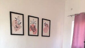 Una sala de estar con un sofá, una mesa de centro y tres cuadros enmarcados.