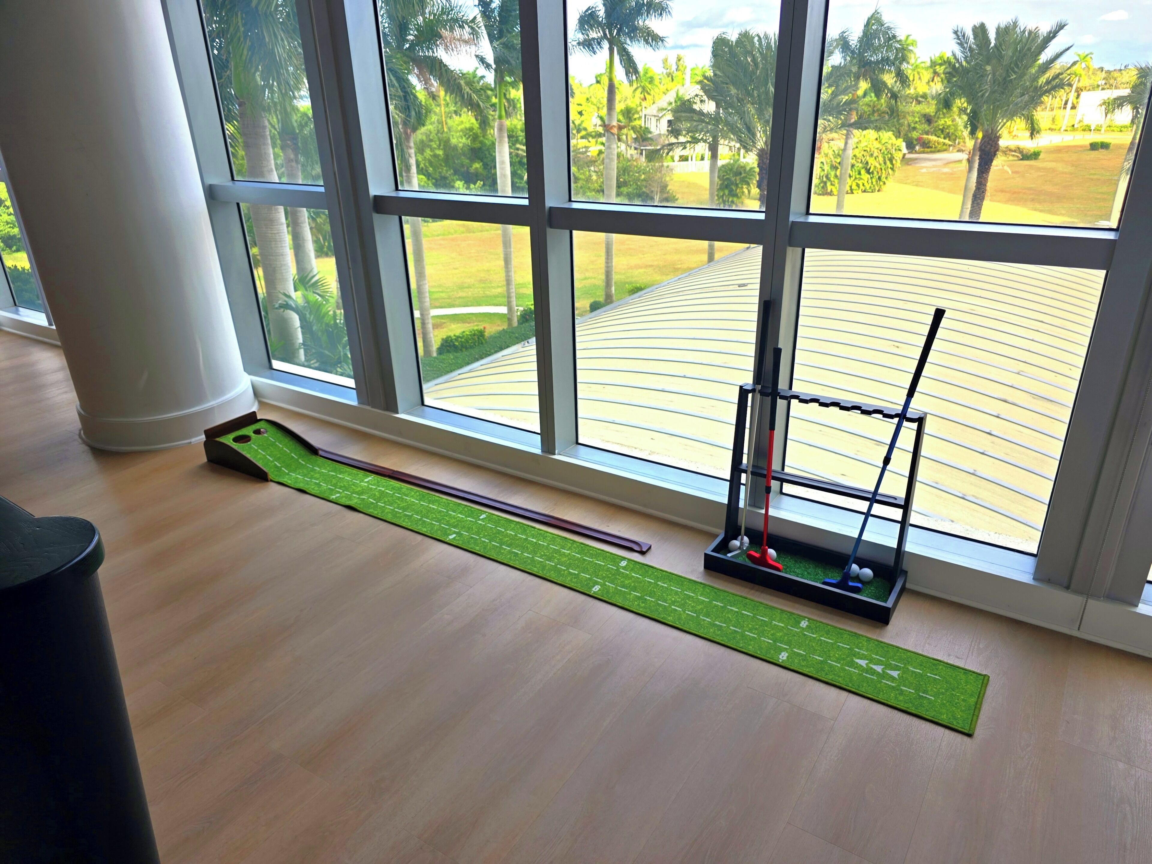 Ein Zimmer mit großem Fenster, einer Minigolf-Bahn und einer Minigolf-Anlage.
