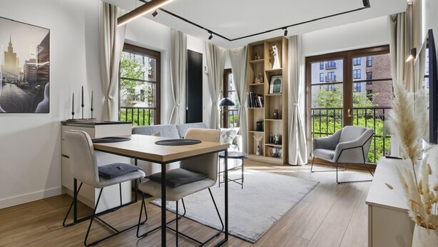 Sala de estar moderna com área de jantar, janelas amplas e vista para a cidade.