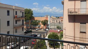 A residential area with buildings, a street, and a distant view of mountains. - Arte Mia suite (Reggio Calabria)