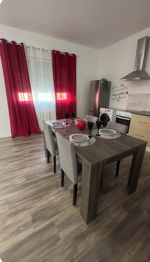A dining area with a wooden table set for four, surrounded by chairs. - Aaron's'Open Space (Montluçon)