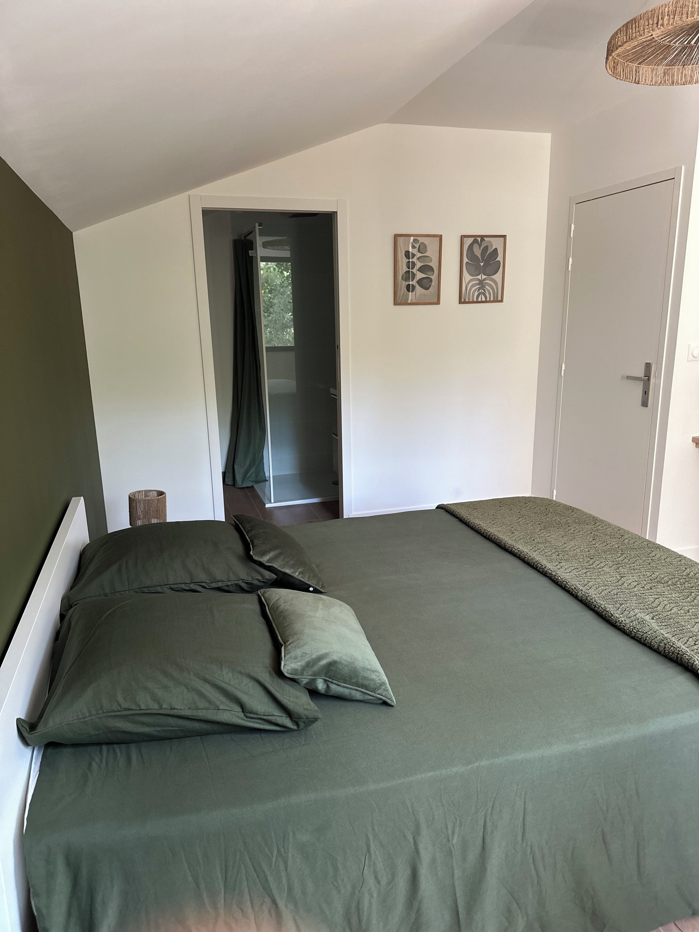 A bedroom with a bed, a door, and a window.