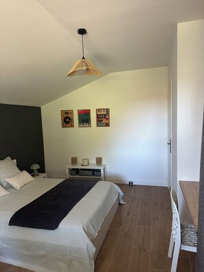 A bedroom with a bed, bedside tables, a hanging light fixture, and wall art. - New house 155 m² /Seaside on foot (100 m)/4 beautiful bedrooms, garden, parking (Saint-Brevin-les-Pins)