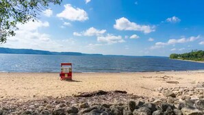 En strand med en livredderstand og en klippefremspring.