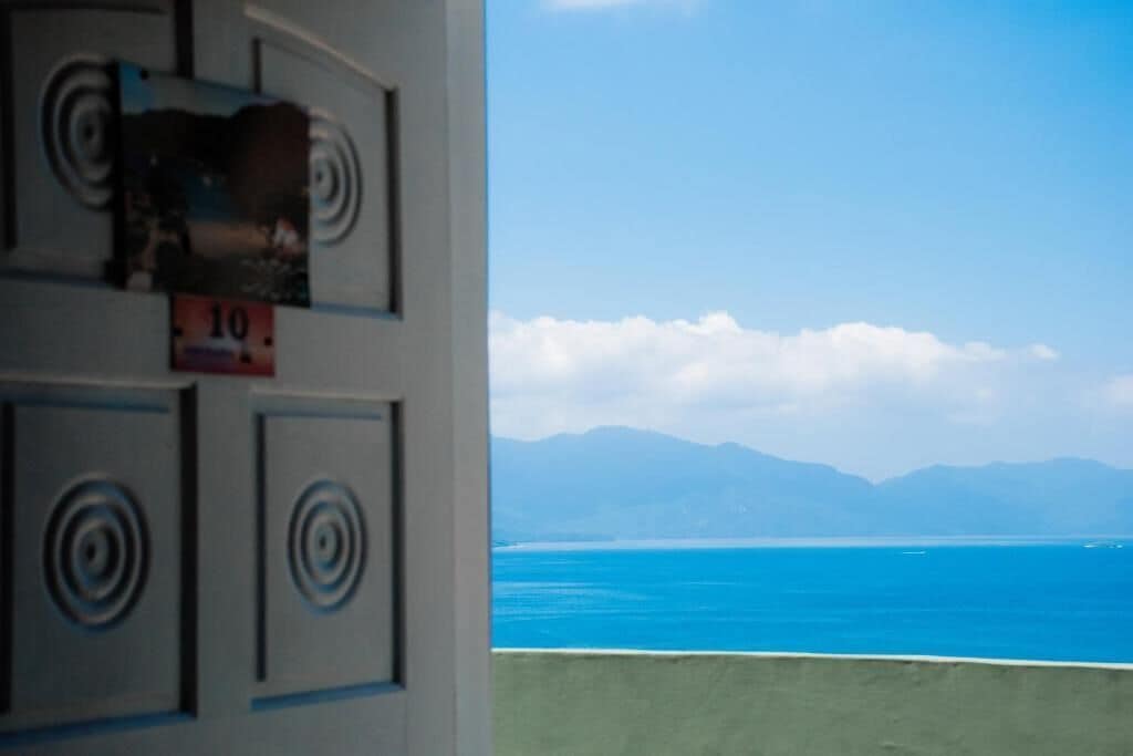 A room with a view of the sea and mountains.