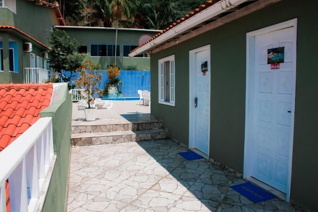 A building with a tiled patio, a swimming pool, and a door with a poster.