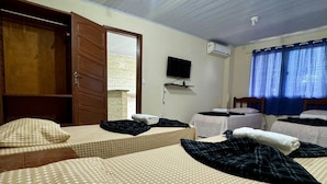 Een hotelkamer met twee bedden, een televisie en een raam met gordijnen.