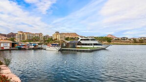 A marina with boats docked, a large building with multiple floors, and a mountain in the background. - Resort-Style 4BR Home in Lake Las Vegas-Near Strip (Henderson)