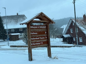 Et træskilt med pile, der viser vej til forskellige destinationer.
