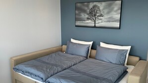 A double bed with grey bedding, a beige headboard, and a wall-mounted picture of a tree. - Beautiful ocean and fjord view short distance to Bergen (Vestland)