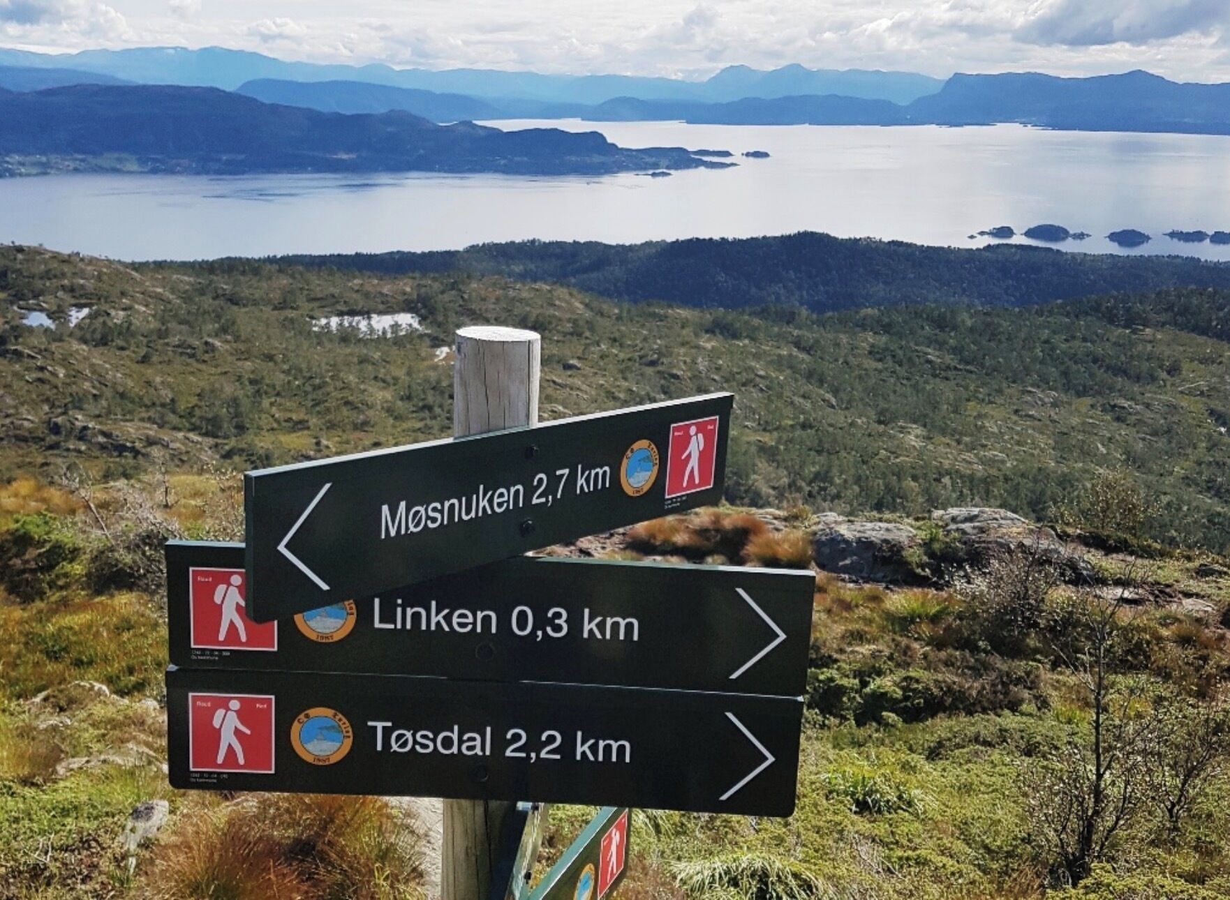 Un panneau indicateur indiquant les directions vers Mosnuken, Linken et Tøsdal.