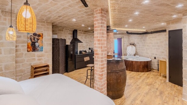 A cozy room with a bed, a wooden barrel, a kitchen area, and a bathroom with a bathtub. - Romantic accommodation for two with Moonlove duo whirlpool bath (Vence)
