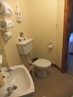 A bathroom with a sink, toilet, and a towel rack with towels.