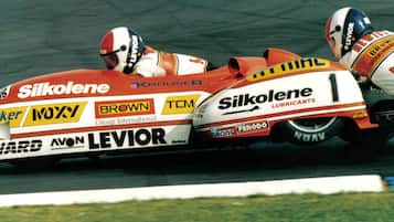 A racing motorcycle with multiple sponsor logos, including Silkolene, Parker, and Brown.