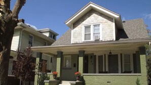 A two-story house with a front porch, a small front yard, and a brick exterior. - Enjoyable 4-bedroom house with AC in charming Highland Park (Highland Park)