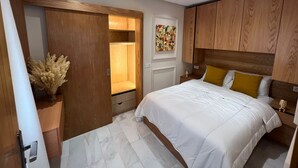 Une chambre à coucher avec un lit, une armoire en bois et une table de chevet.