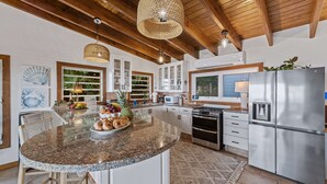 Una cocina moderna con encimeras de granito, electrodomésticos de acero inoxidable y una isla grande.