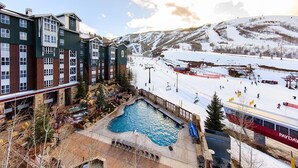 Ein Hotel mit Pool, Skipiste und Bergblick.