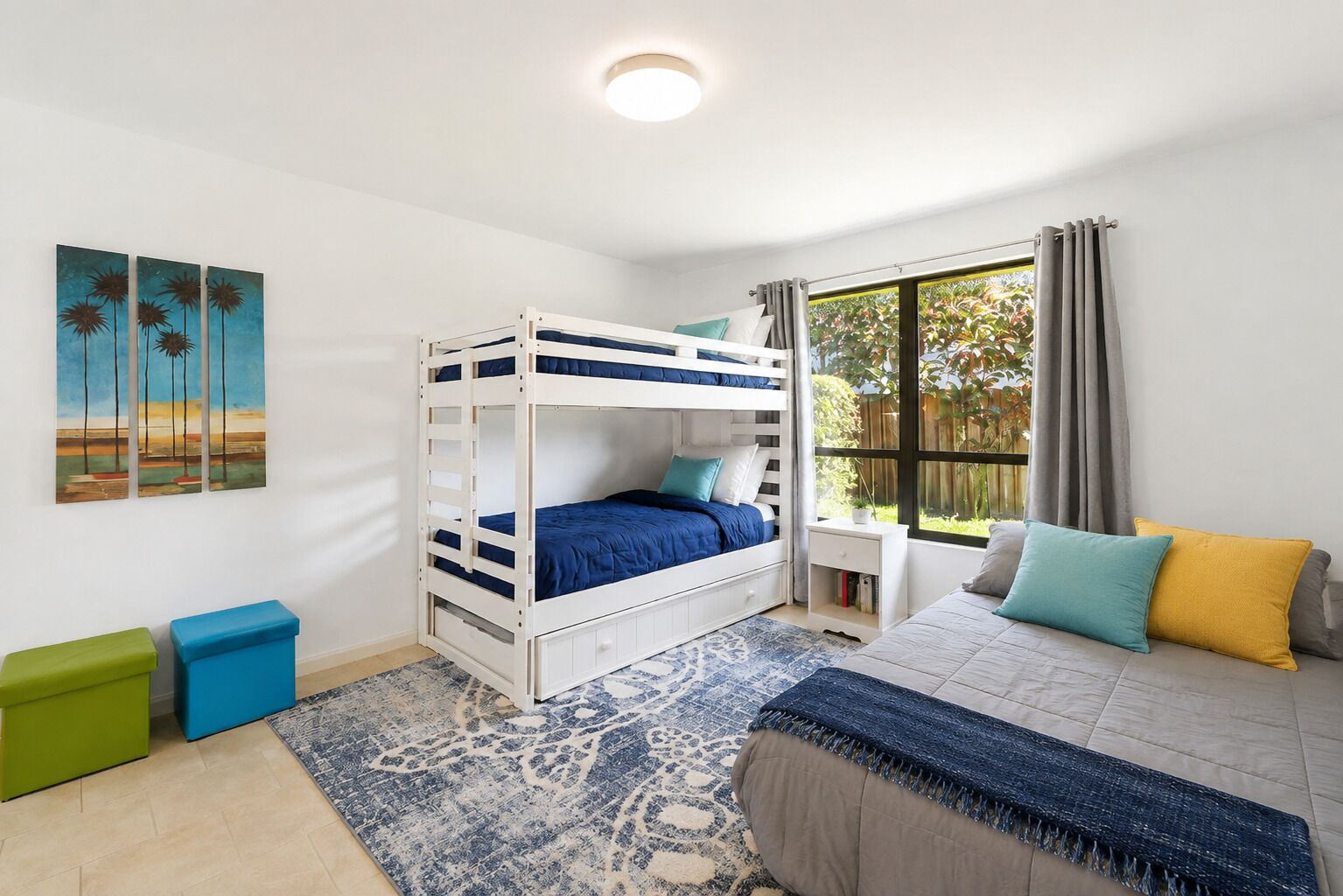 A bedroom with a bunk bed, a bedside table, a window with curtains, a rug, and a painting on the wall.