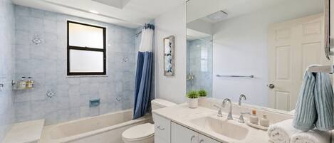 A modern bathroom with a bathtub, toilet, and sink.