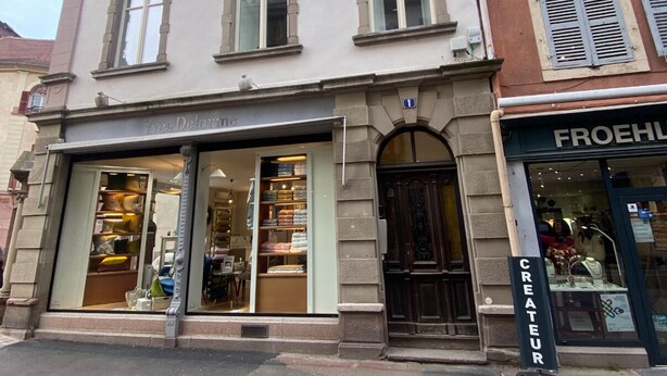 Ein Gebäude mit einem Geschäft im Erdgeschoss namens 'Yves Delorme' und einem Geschäft im zweiten Stock namens 'FROEHLE'.