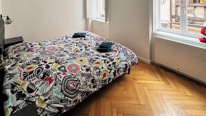 Ein Schlafzimmer mit Bett, Fenster und Heizkörper.