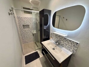 Een douche, een haardroger, handdoeken, toiletpapier
