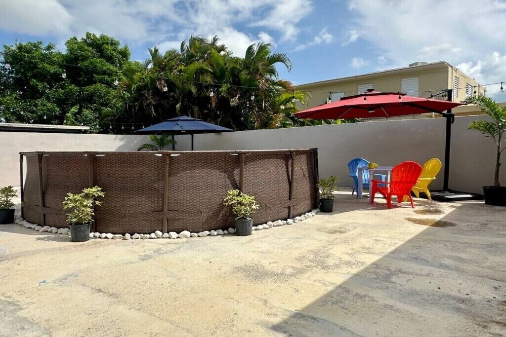 A patio area with a woven partition, outdoor furniture, and potted plants.