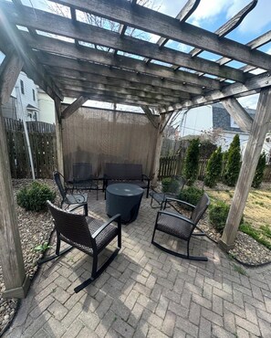 A covered patio with outdoor furniture, a pergola, and a view of the backyard.
