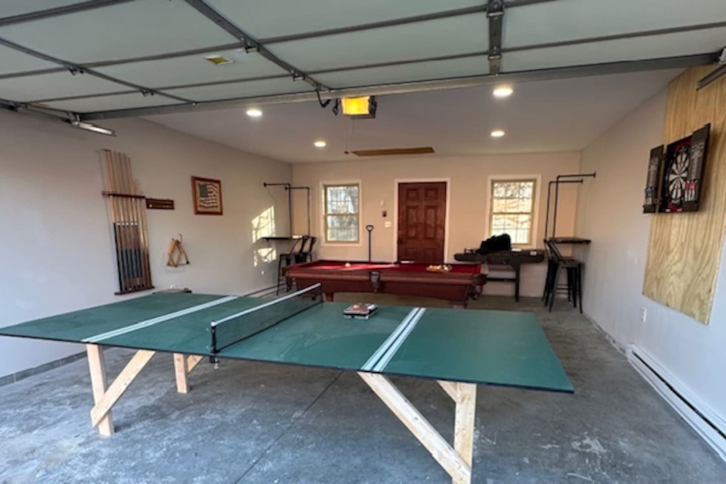 A room with a ping pong table, a pool table, and a billiards table.