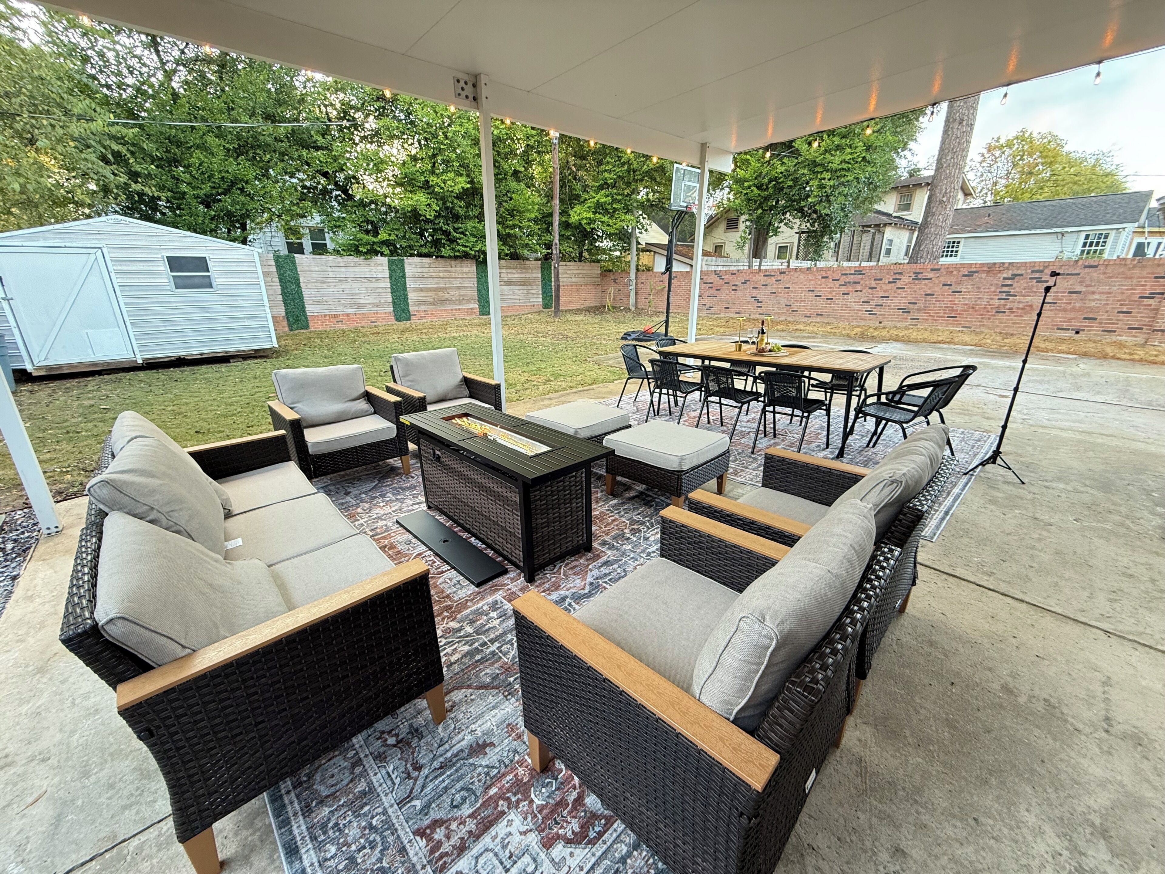 An outdoor patio area with wicker furniture, including sofas, chairs, and a coffee table.