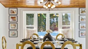 A dining area with a glass table, gold chairs, and a view of a pool. - King Bed w/ Game Room near Massmutual w/ Riverview (Chicopee)