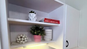A kitchen with white cabinets, a wooden countertop, and a shelf with a book and a potted plant. - Welcome to Saltwater Escape in Swansea. (Swansea)