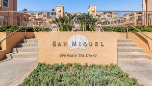 En skylt med texten ”San Miguel” vid adressen 500 North The Strand, med en trappa som leder upp till entrén.