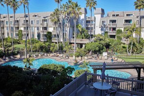 A hotel with multiple floors, outdoor swimming pool, and palm trees. - North Coast Village D204 (Oceanside)