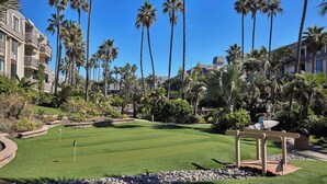 Un parcours de golf bien entretenu, offrant une vue dégagée sur les palmiers et les bâtiments de l’hôtel environnants.